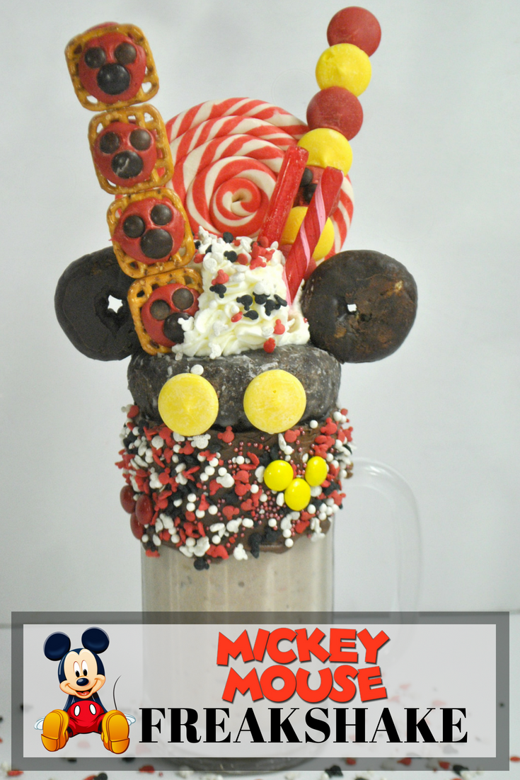 This Mickey Mouse Milkshake is so much fun to make - perfect to celebrate his 90th birthday or for a party. Topped with donuts, candy and pretzels, this Mickey freak shake will be a delicious treat. #freakshake #milkshake #disneyrecipe #disney #mikeymouse