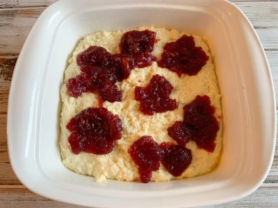 Adding cranberry on top of the baking mix batter Adding cranberry on top of the baking mix batter