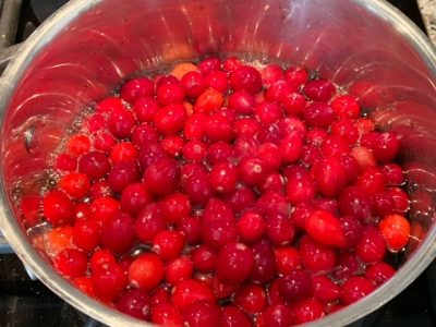 Fresh cranberries popping over stovetop and cooking Fresh cranberries popping over stovetop and cooking