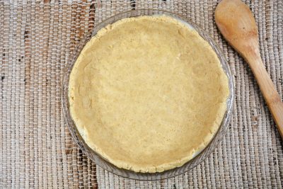 Pressing dough into bottom of pie dish Pressing dough into bottom of pie dish